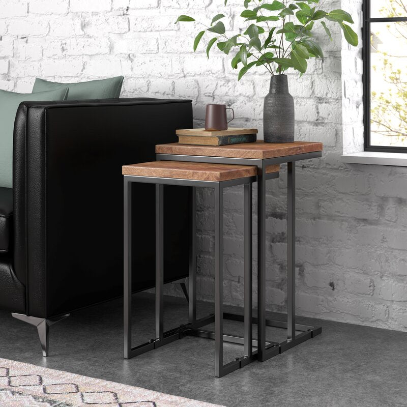 Nesting tables set with wood tops and metal frames, next to a sofa 