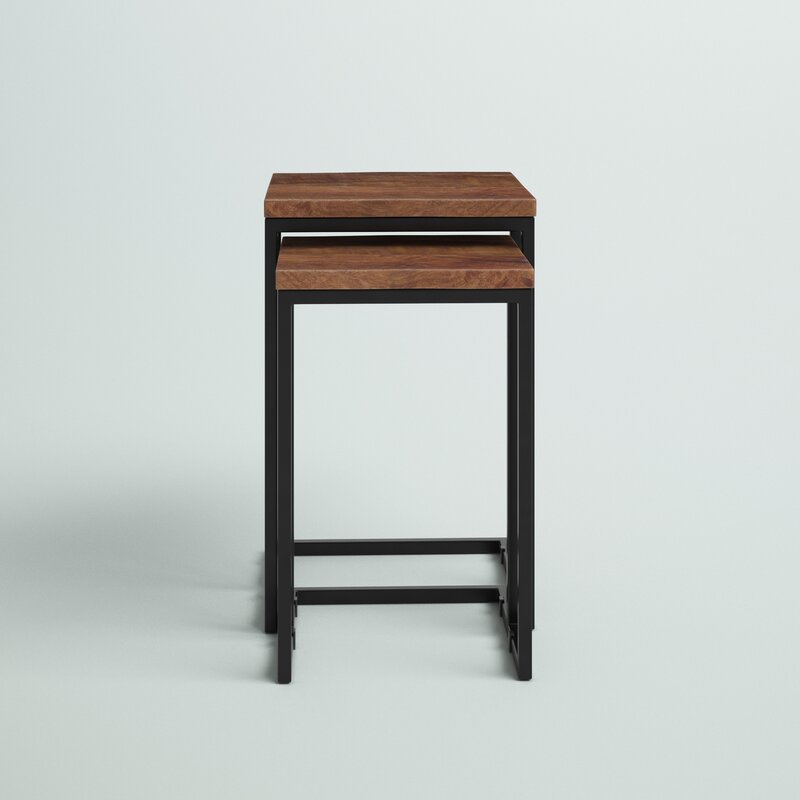 Nesting tables set with wood tops and metal frames, next to a sofa